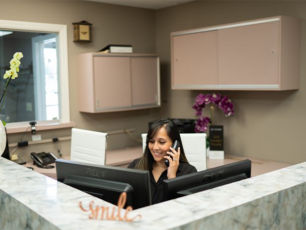 Dentist talking to two dental team members at reception desk