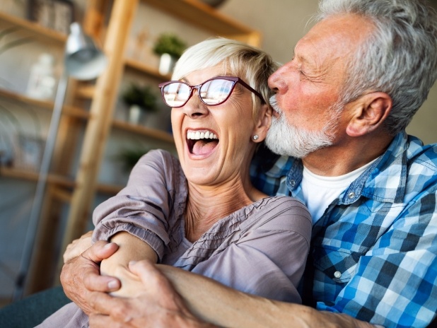 Man and woman smiling after restorative dentistry