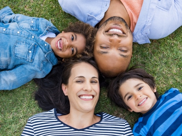 Family of four smiling after children's dentistry visit