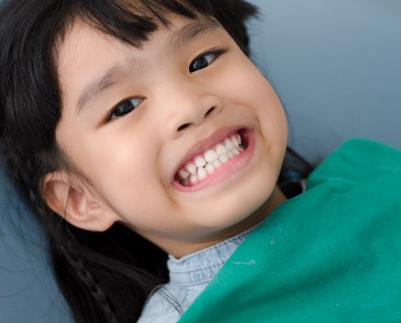 Young patient smiling after dental checkup and teeth cleaning visit