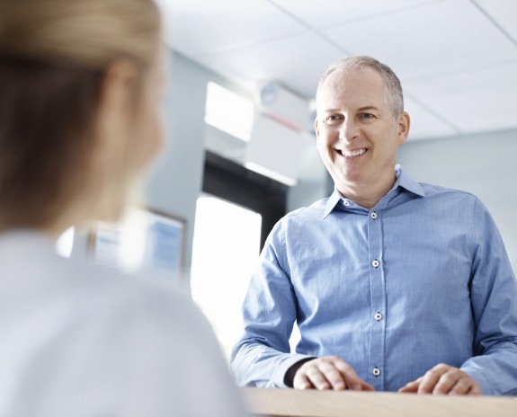 Man discussing the cost of dental emergencies with team member