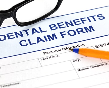 Dental insurance paperwork with pen and glasses