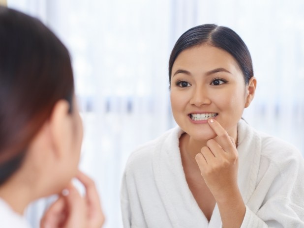 Woman looking at healthy smile after periodontal disease treatment