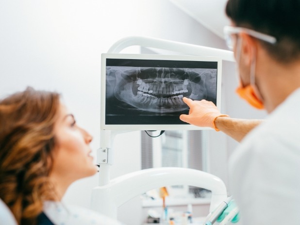 Dentist and patient looking at digital x-rays