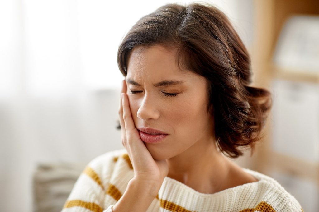 Woman experiencing a toothache due to a cavity.