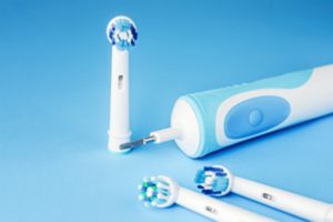 Electric toothbrush against a blue background.  